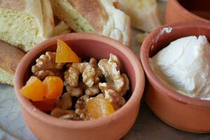 walnut and peach fruit in a small bowl on table photo