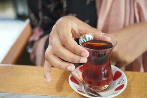 women drinking Traditional turkish tea on white table . photo