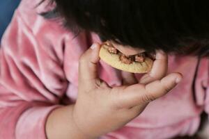 child mouth eating chocolate sweet cookies photo