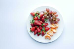 Ripe Red Strawberries, orange and grape fruit on a plate photo