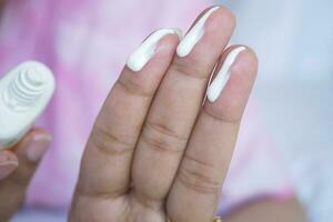 Close up of person hand using sunscreen cream outdoor photo