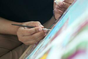 women hand holding brush with paint photo