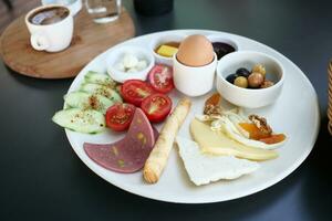 turkish breakfast of cheese, sausage, cucumber, egg, olive and tomato photo