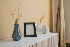 empty photo frame and decorative flower on tv cabinet