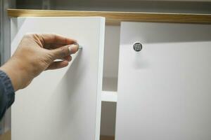 man's hand open drawer wooden in cabinet photo