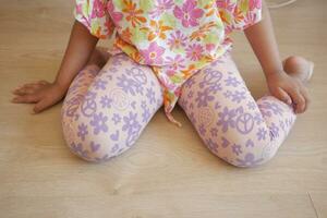 child sitting W posture on the floor . photo