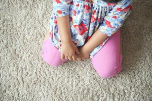 child sitting W posture on the floor . photo