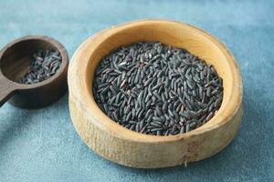 Black Rice Grains in a wooden bowl . photo