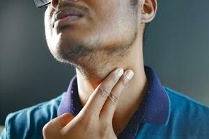 hombre no reconocido tocándose el cuello para controlar la presión arterial foto