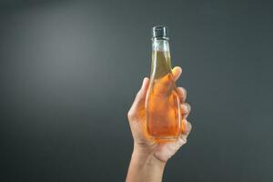 holding a bottle of apple vinegar photo