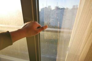 hand open gray plastic pvc window at home at early morning photo