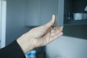 women hand open a kitchen cabinet drawer photo