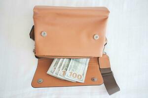 us dollar cash in leather women purse on bed photo