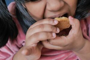 close up of child eating sweet cookies photo