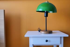 mesa lámpara en contra naranja color pared en cama habitación foto