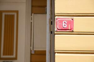 house number six. Decorative lettering on a brick wall. photo