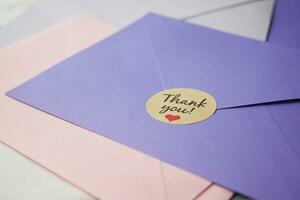 thank you message and envelope on wooden table photo