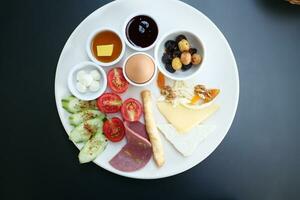 turkish breakfast of cheese, cucumber, egg, olive and tomato photo