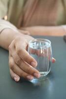 mujer participación un vaso de agua en mesa foto