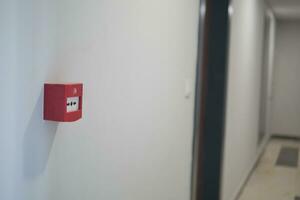 Red fire alarm button on wall , photo