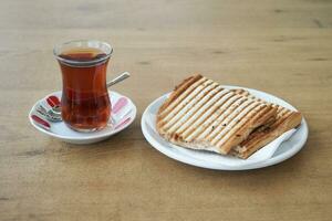Traditional turkish tea and a sandwich on table photo