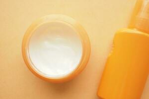 Close up of sunscreen cream on orange background photo