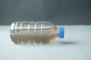 dirty bottle of plastic water on table photo