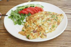 llanura huevo tortilla y Fresco ensalada para desayuno en mesa foto