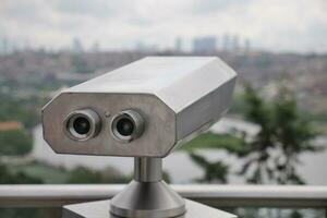 Coinoperated binoculars looking out over city , photo