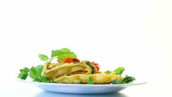 Egg omelet stuffed with tomato and greens fried in the form of waffles, isolated on white background video