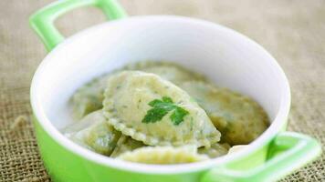 Boiled dumplings with stuffing inside, from dough with herbs in a ceramic plate. video