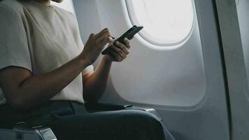 Traveling and technology. Flying at first class. Pretty young businees woman using smartphone while sitting in airplane. video