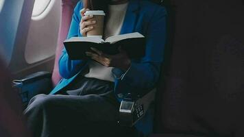 Successful female book editor reading literature during time in airplane before business meeting with writer, confident formally dressed woman enjoying international flight and leisure for novel video