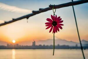 a flower hanging from a branch with a sunset in the background. AI-Generated photo