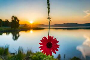 a red flower hangs from a hook over a lake at sunset. AI-Generated photo