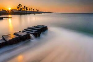 a long exposure photograph of a beach with a rock wall and palm trees. AI-Generated photo