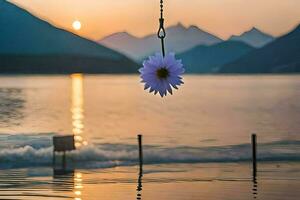 a flower hanging from a rope over a lake. AI-Generated photo