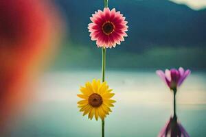 three colorful flowers are standing on a pole in front of a lake. AI-Generated photo