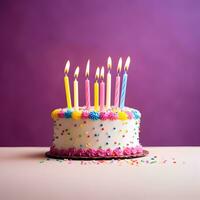 Birthday cake with candles on magenta background photo