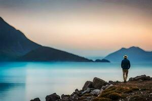 a man standing on rocks overlooking a lake at sunset. AI-Generated photo