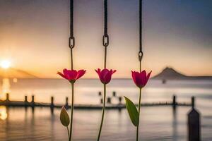 three flowers hanging from a rope in front of a lake. AI-Generated photo