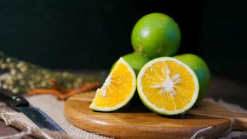 Orange fruit with green peel, half part, and slice with dark mood photography photo