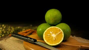 Orange fruit with green peel, half part, and slice with dark mood photography photo