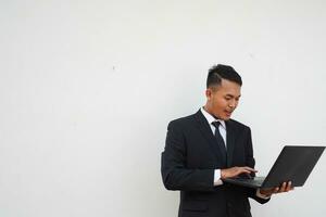 Portrait Young Asian businessman work with laptop isolated on white background photo