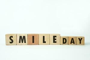 world smile day text on a wooden cube block shape with white background, October 6 photo