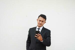 Portrait Young Asian businessman hold mobile phone read and text massage, serious expression, isolated on white background photo