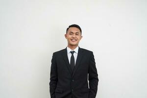 Portrait Young Asian businessman happy and smiling face look at camera hands in trouser pockets isolated on white background photo