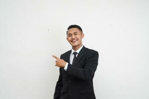 Portrait Young handsome Asian businessman with happy and smiling face finger pointing at copy space isolated on white background photo