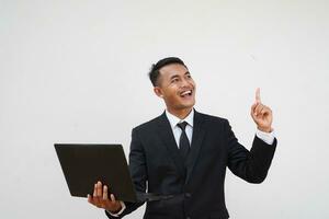 Portrait Young Asian businessman get a idea, smart, finger pointing up, work with laptop isolated on white background photo