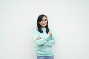 Portrait Indonesian beautiful woman wearing light blue sweater with smiling happy face and thumb up, give praise, agree, isolated on white background photo